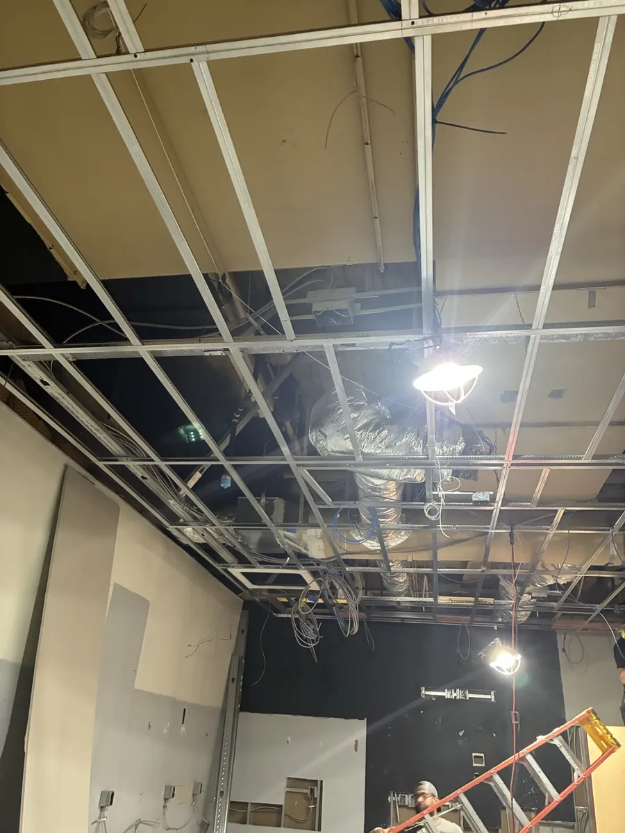 Retail store under demolition with the ceiling grid opened and old wiring exposed