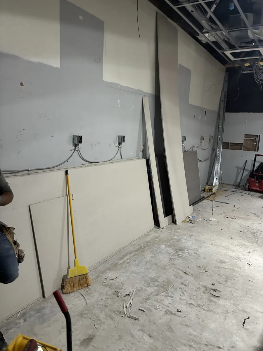 New electrical boxes and conduit roughed in on a bare retail store wall