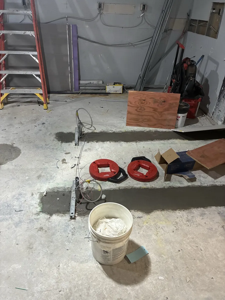 Patched floor trenches carrying conduit to the middle of a retail sales floor