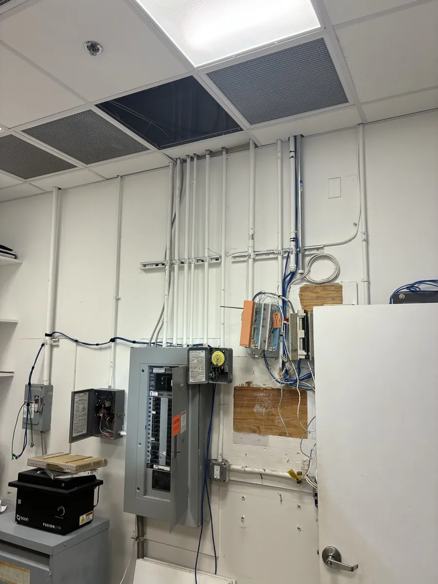 New panelboard installed with conduit runs squared and supported above it